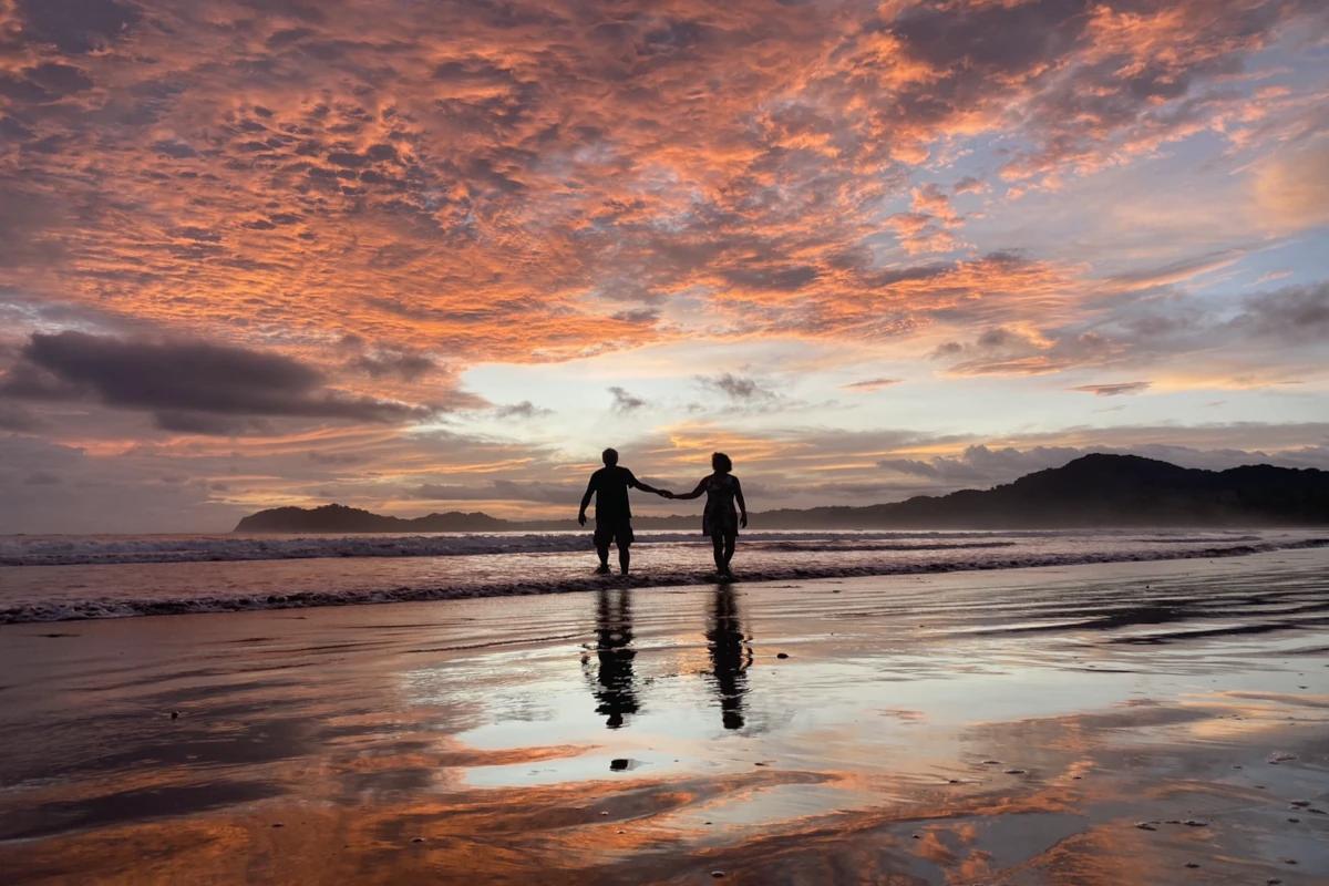 Two people walking in the water at dusk on Samara beach