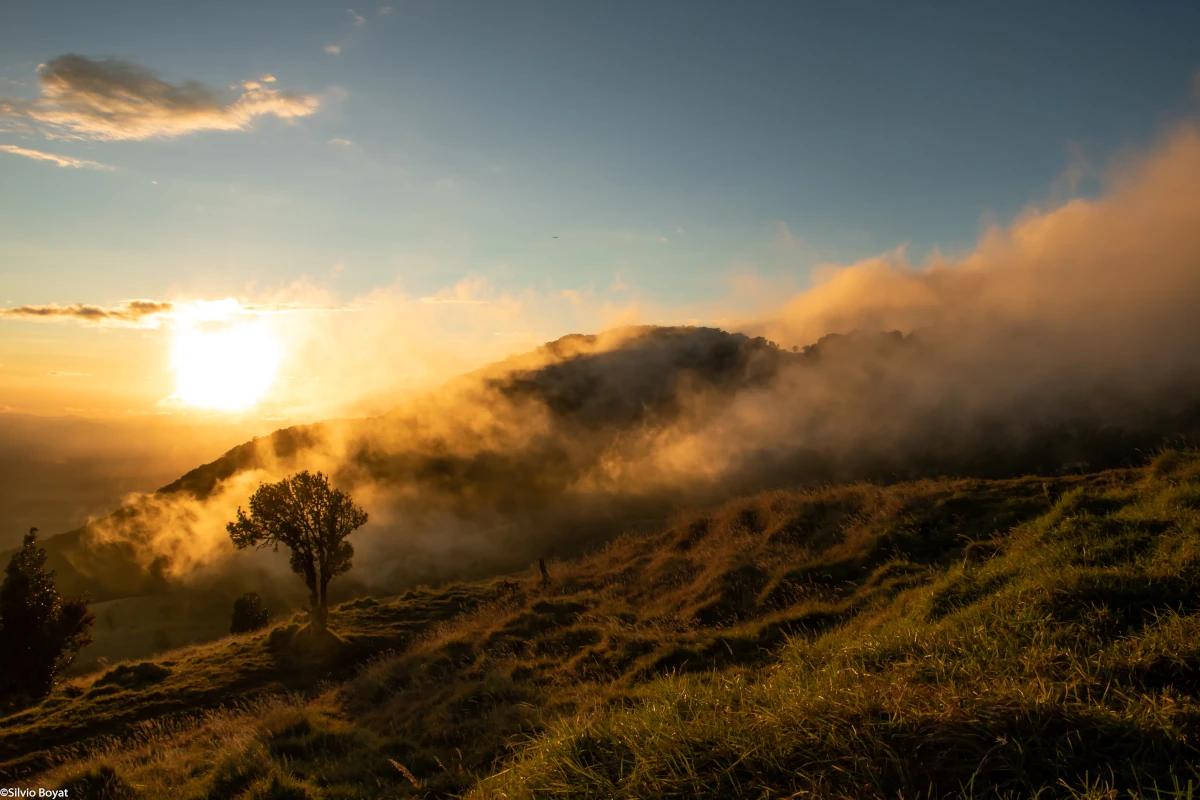 Barva Volcano emerging from the mist and the glow of the sun